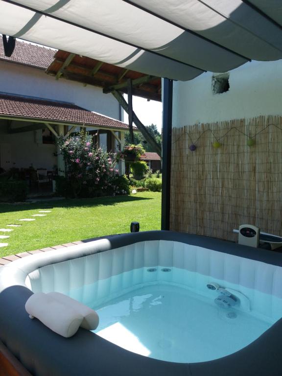 a hot tub in a backyard with an umbrella at Les Eygletières in Bourriot-Bergonce