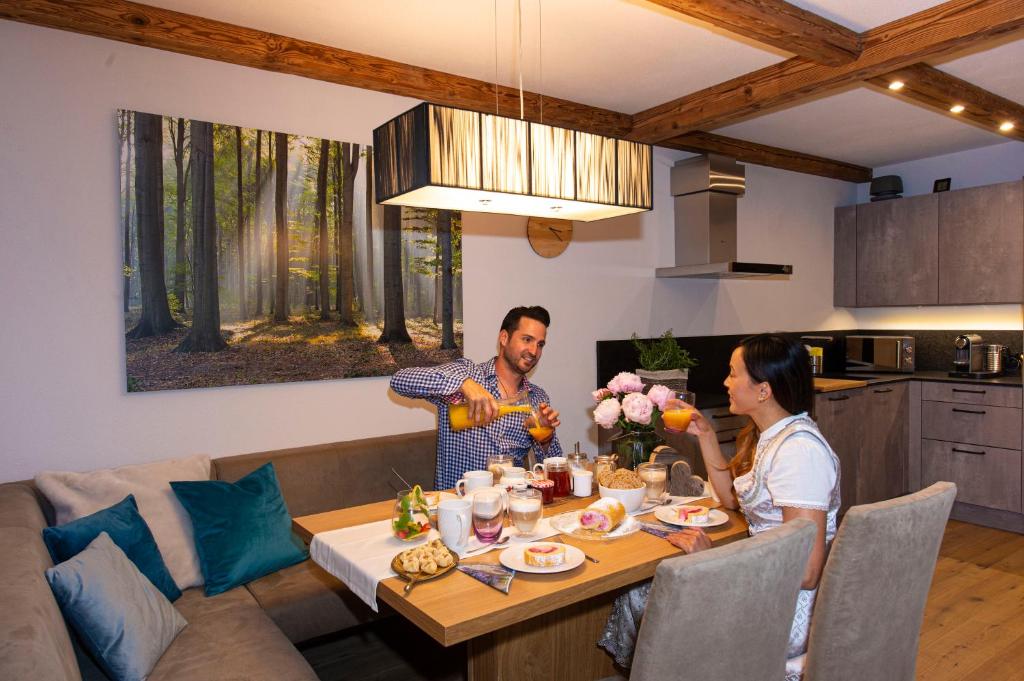 een man en vrouw aan een tafel in een keuken bij Appartement Enzian & Mark in Ellmau