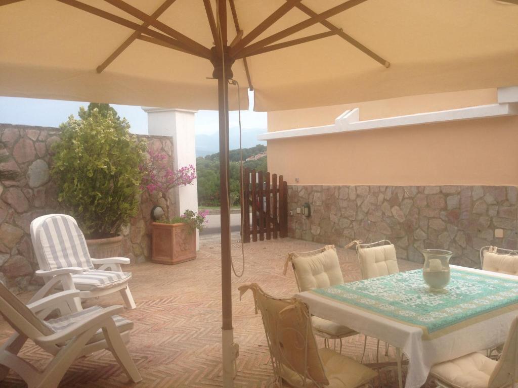patio ze stołem, krzesłami i parasolem w obiekcie Les Amis w mieście Palinuro