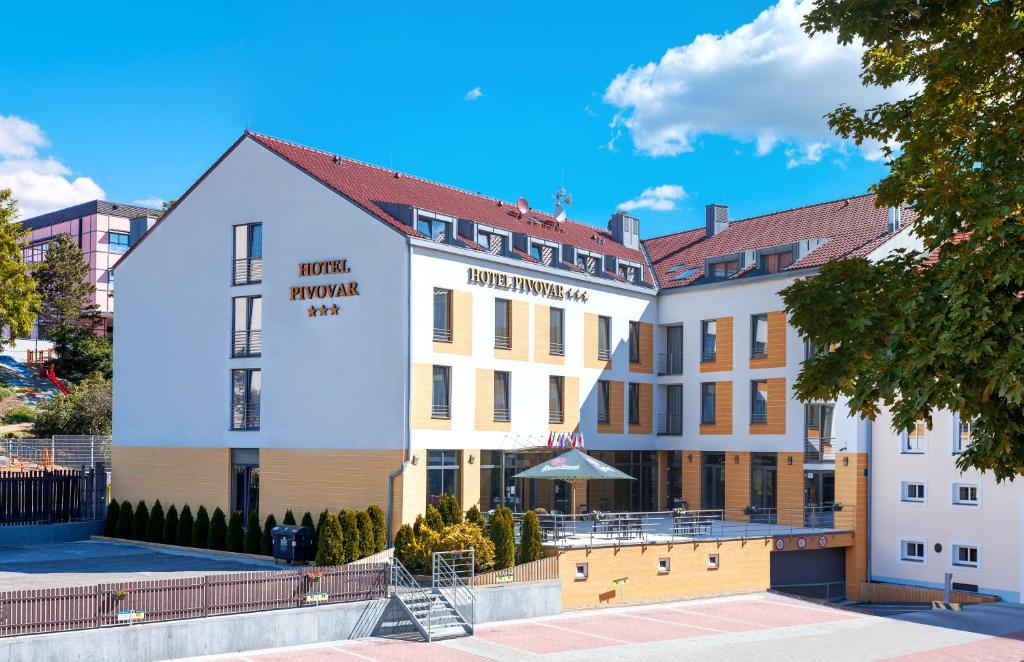 un gran edificio blanco con un cartel. en Hotel Pivovar en Praga