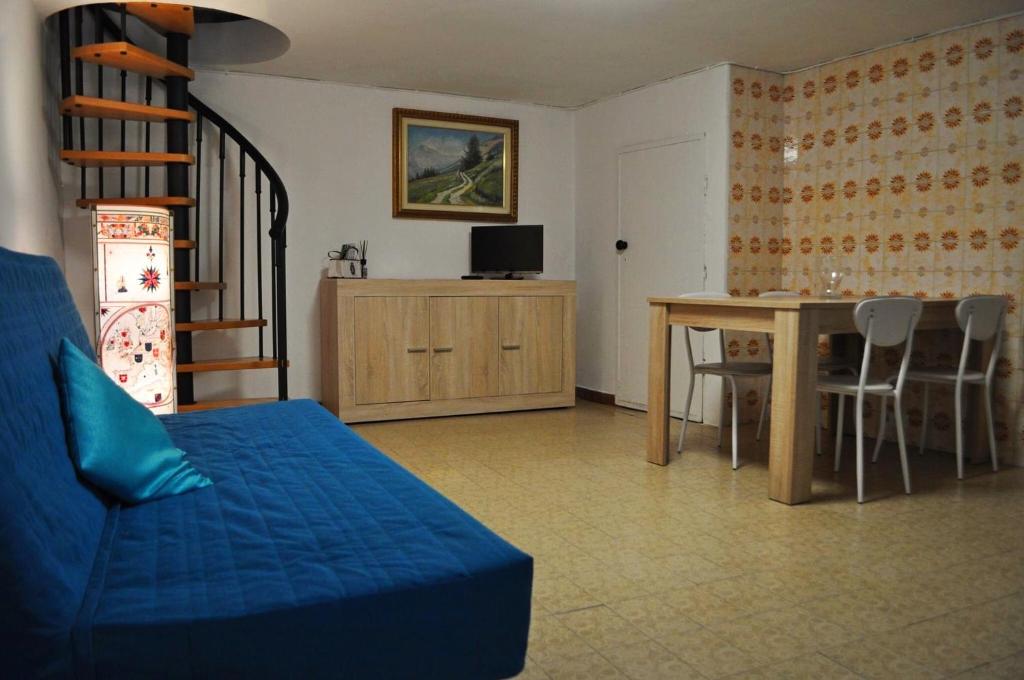 ein Wohnzimmer mit einem blauen Sofa und einem Tisch in der Unterkunft La Casetta nel cuore del Parco in Locana