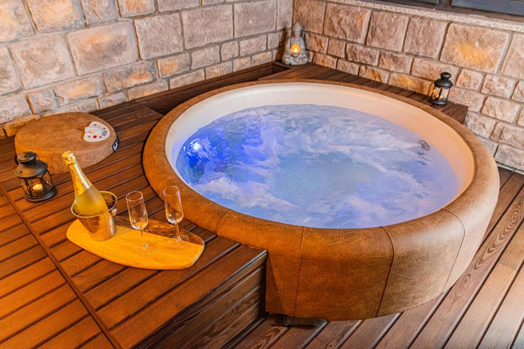 a bath tub with a bottle of wine and glasses at Jacuzzi - Flexible SelfCheckIns 20 - Zagreb - Luxury - Garage - Smart - Brand New - Apartments Repinc in Zagreb