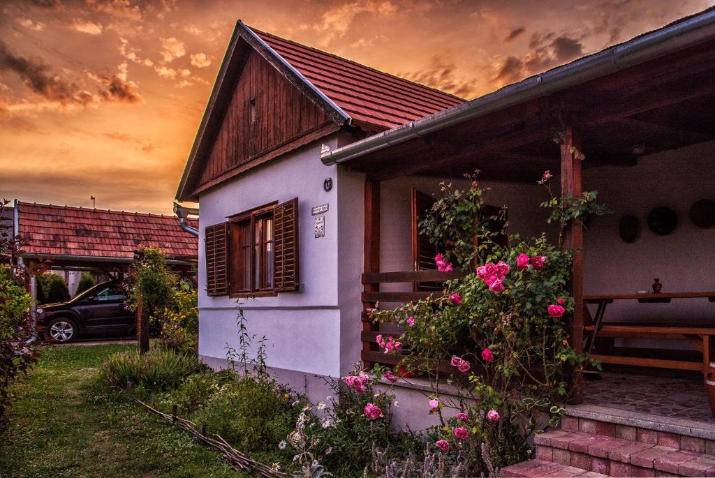 ein kleines weißes Haus mit Blumen davor in der Unterkunft Csavargó Tanya in Szalafő
