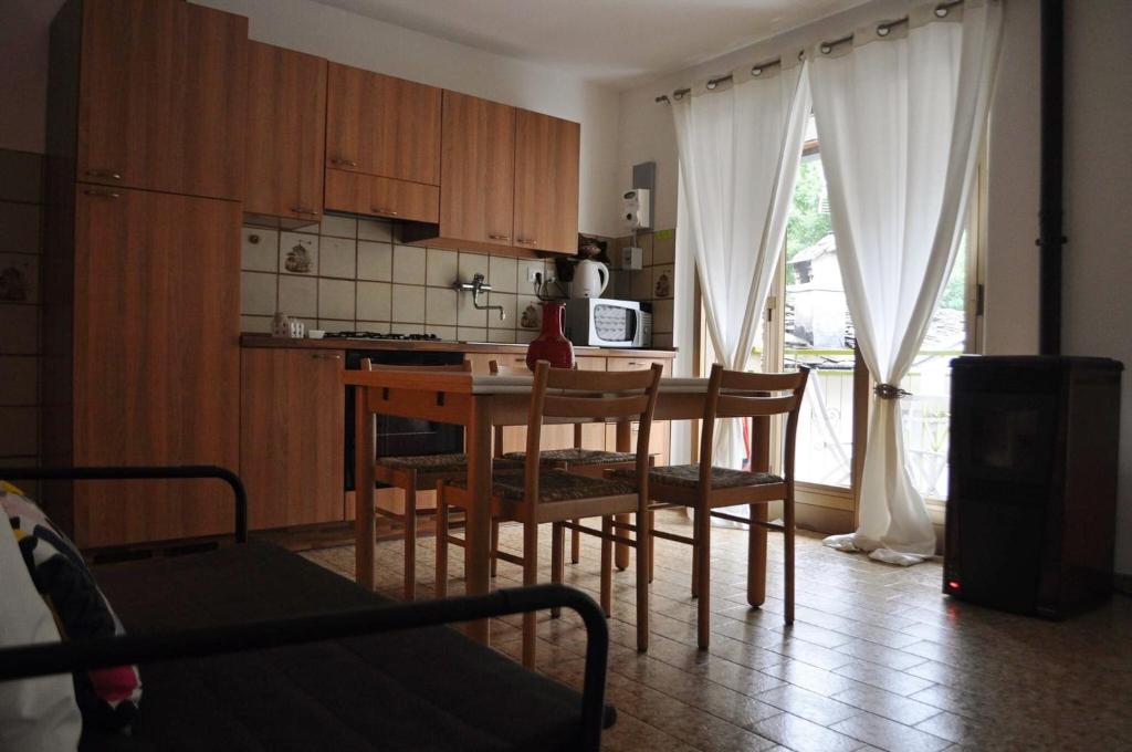 a kitchen with a table and chairs and a kitchen with a window at Il bilocale della nonna in Locana