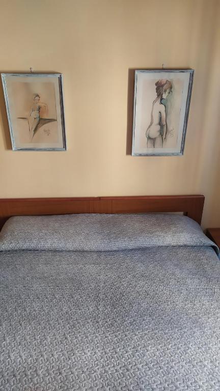 ポルト・トッレスにあるAffittacamere Da Priscillaの壁に2枚の写真が飾られたベッドルーム1室、ベッド1台が備わります。