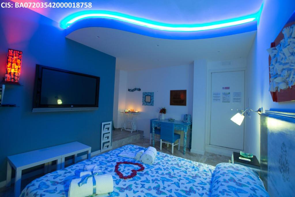 a blue room with a bed and a tv at Versomare in Polignano a Mare