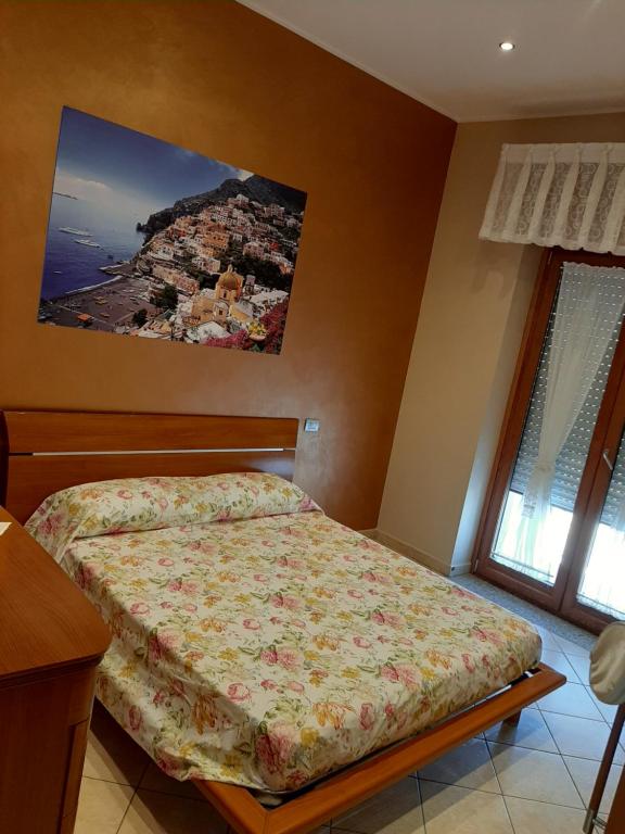 ein Schlafzimmer mit einem Bett und einem Bild an der Wand in der Unterkunft Beautiful beb in Neapel