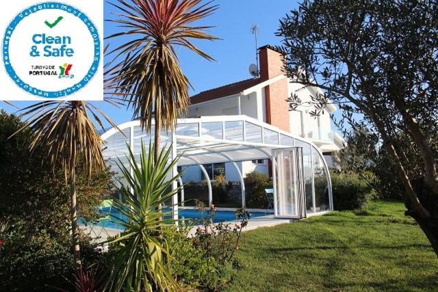 a greenhouse in front of a house with a palm tree at B&B Villa Vale Flores in Viana do Castelo