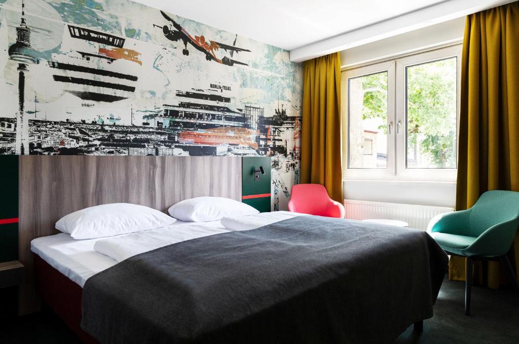 a bedroom with a bed and two chairs at Good Morning Berlin City West in Berlin