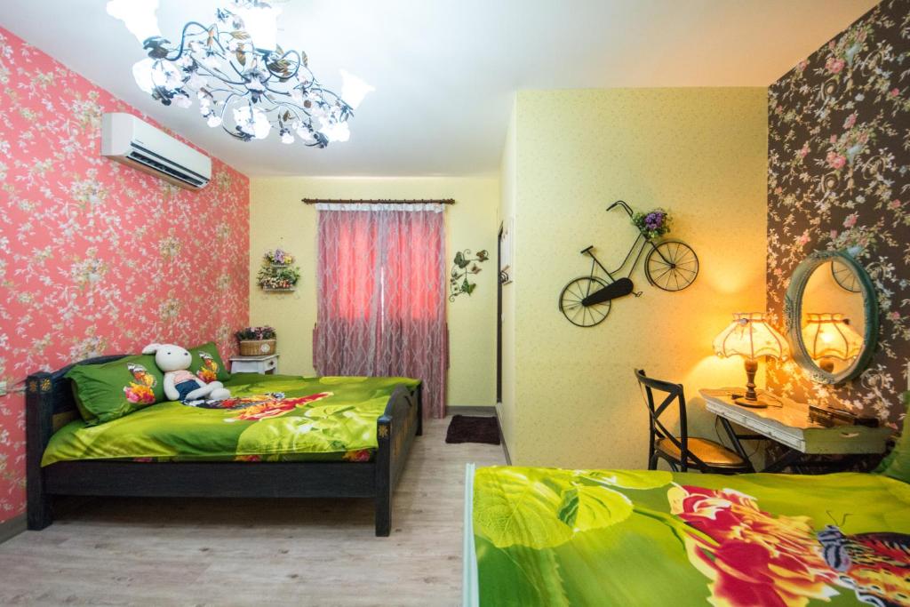 a bedroom with two beds and a desk with a bike on the wall at Sunflower B&amp;B II in Hualien City