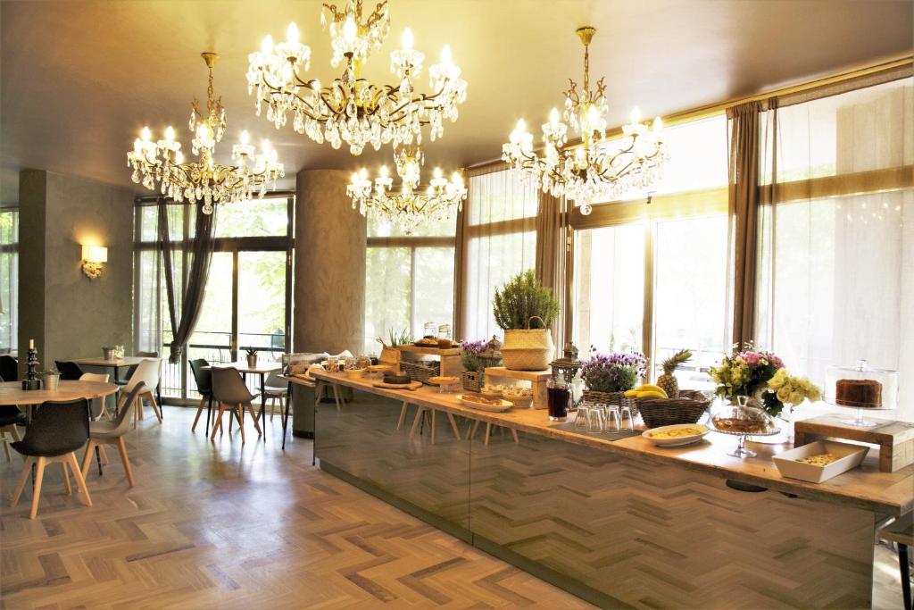 a kitchen with chandeliers and a counter with tables and chairs at Hotel Anna Gabicce Mare in Gabicce Mare