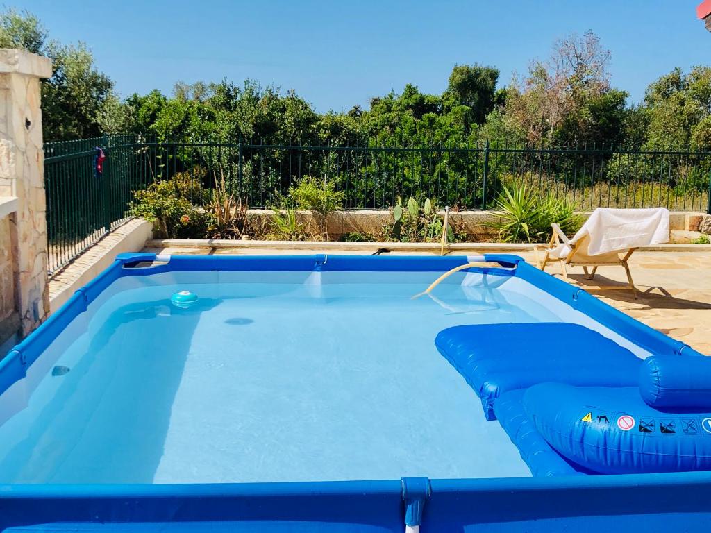 una gran piscina azul con una silla en un patio en Villa Dina e Mario, en Torre Pali
