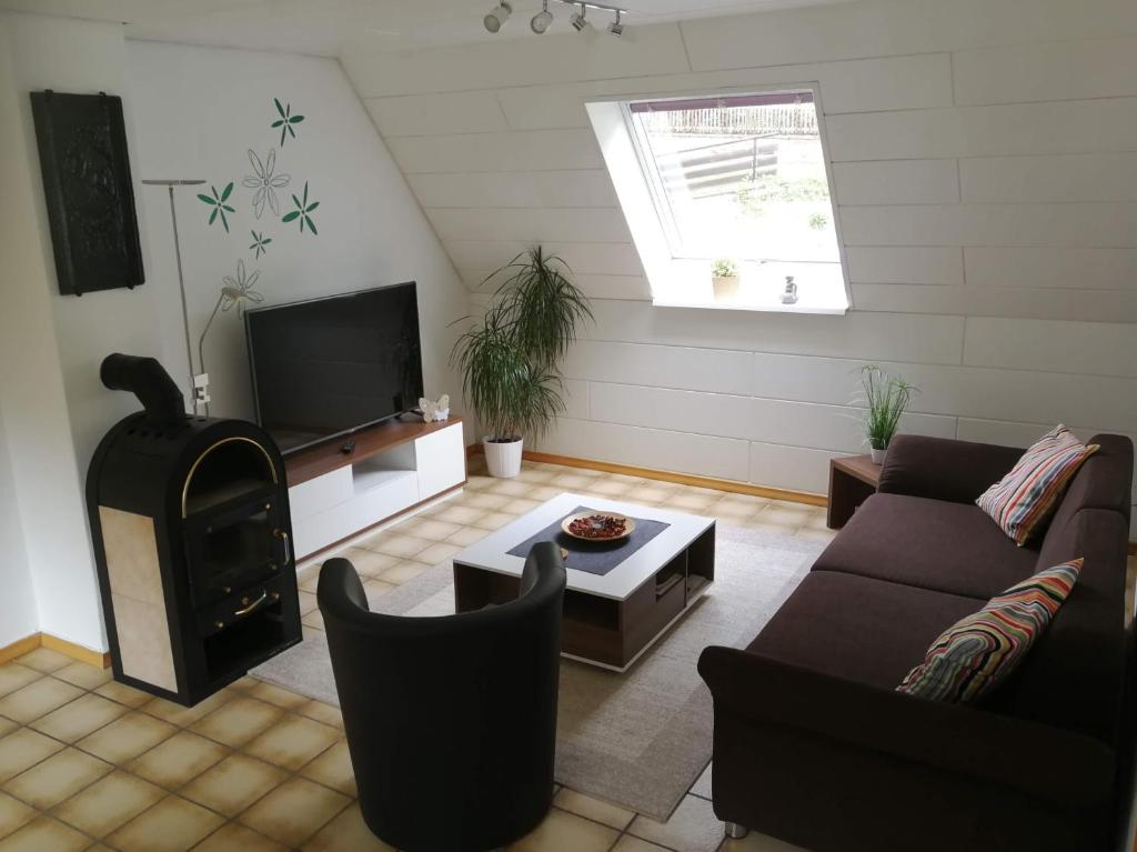 a living room with a couch and a stove at Ferienwohnung Zenzen in Adenau