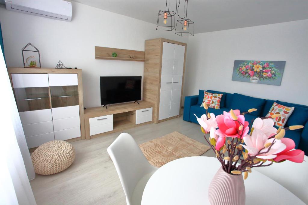 a living room with a table and a blue couch at Apartament Delora View in Bumbeşti-Jiu