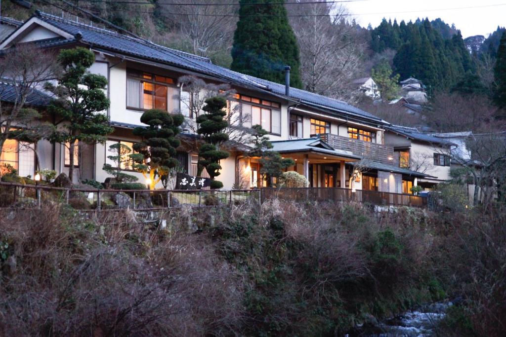 a house on a hill with lights on at Shimizu Ryokan in Yufu