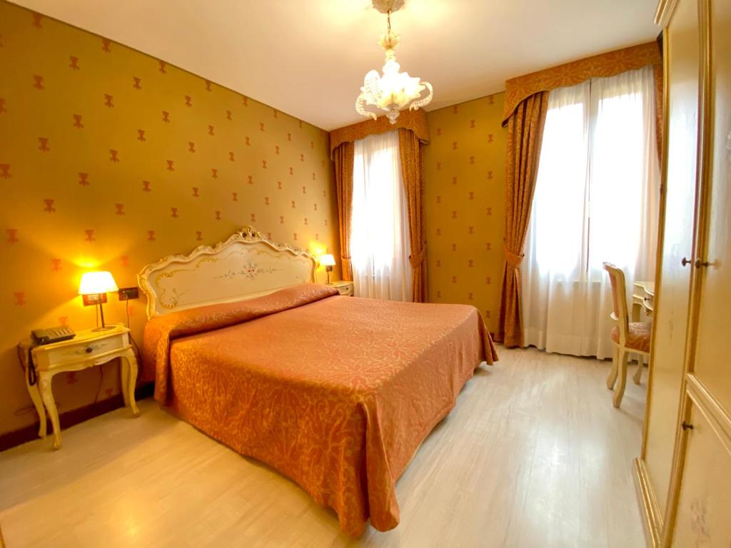 a bedroom with a bed and a table with a lamp at San Gallo Hotel in Venice