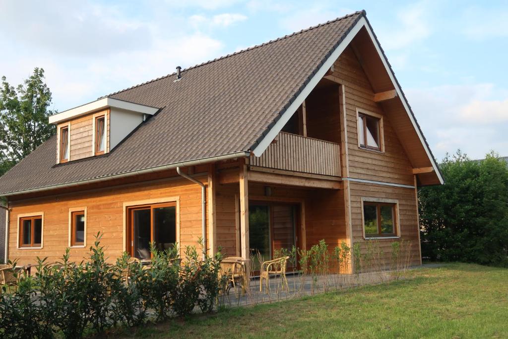 ein Holzhaus mit einem Gameradach in der Unterkunft Familiehuis Klokkenweide in Loon op Zand