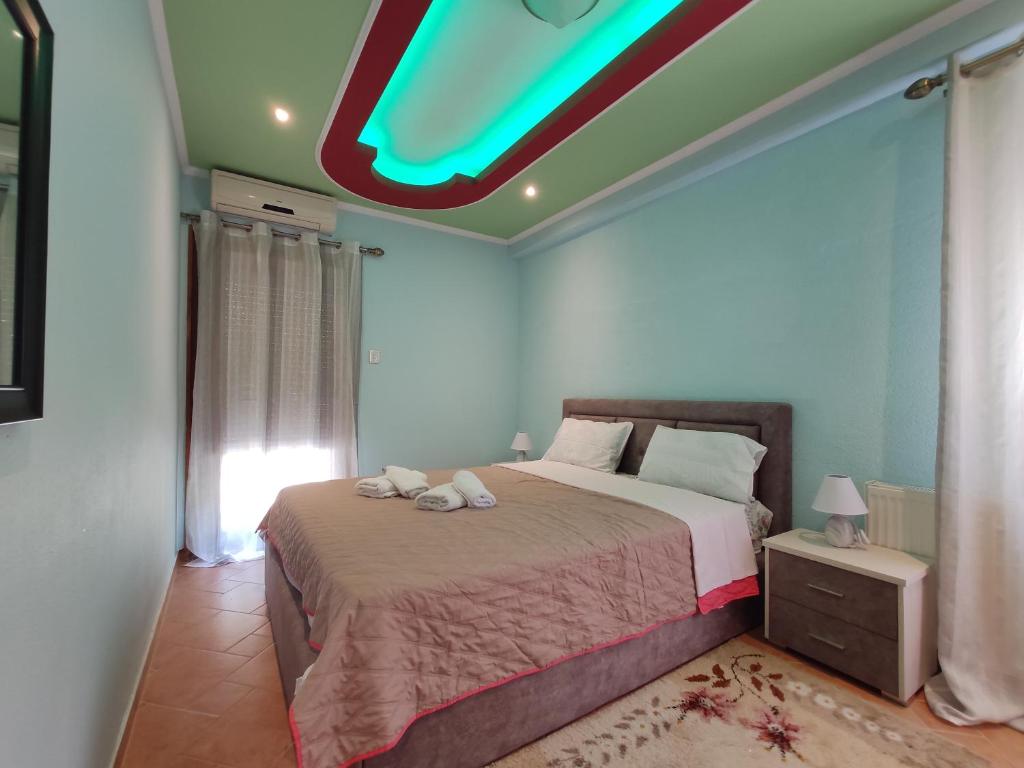 a bedroom with a bed with a green ceiling at Elpida Apartment in Limenas
