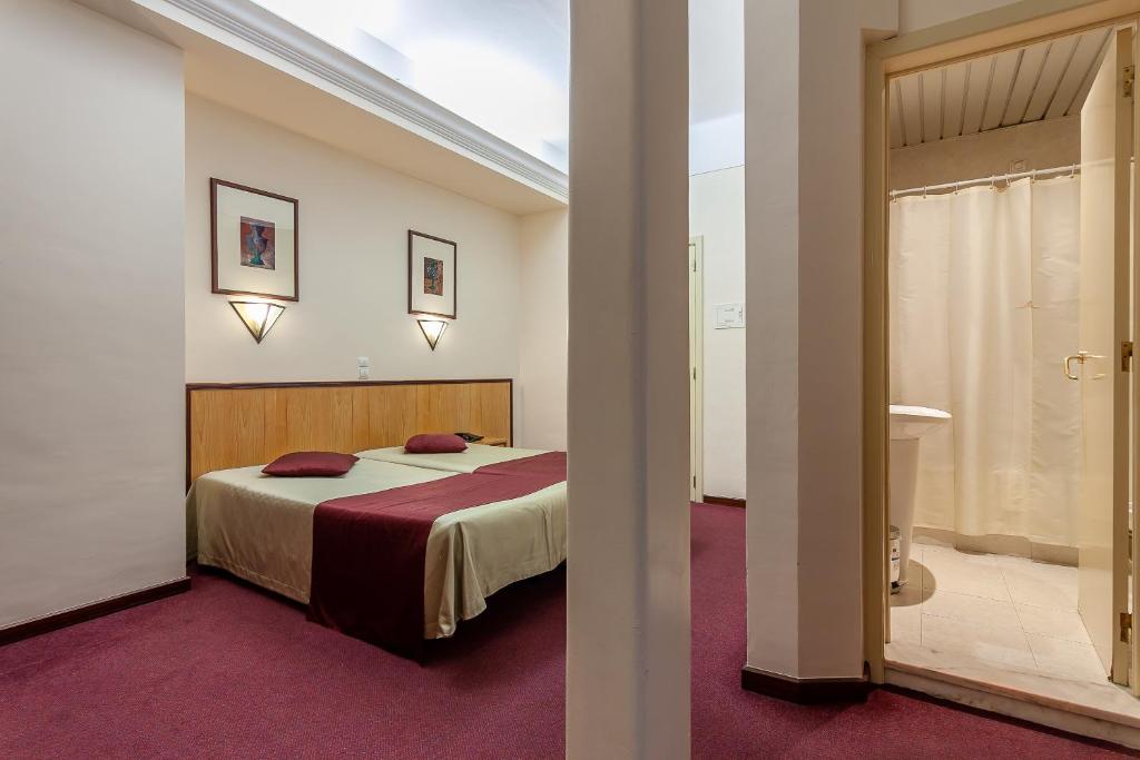 Habitación de hotel con cama y baño en Residencial Horizonte en Lisboa