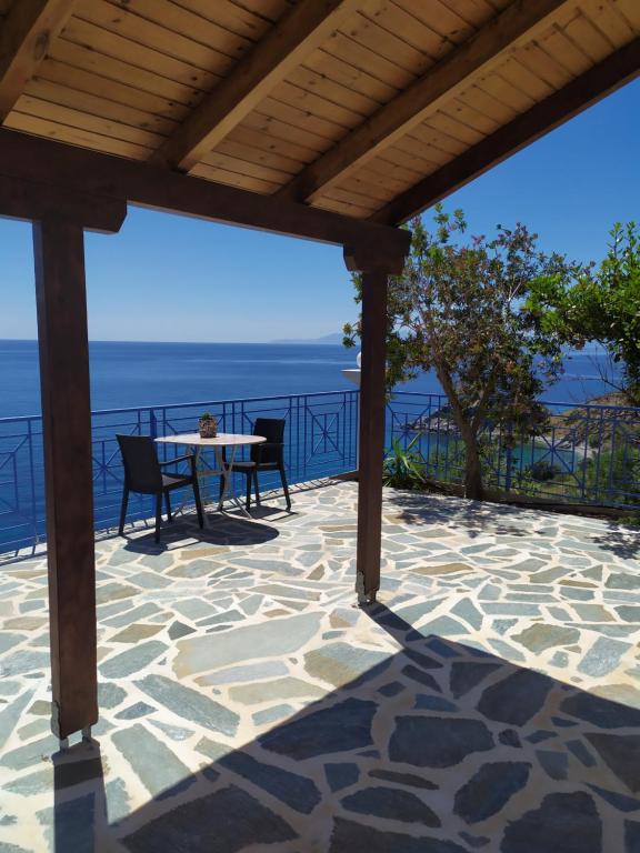 un patio con tavolo, sedie e vista sull'oceano di Korasida Blue Coast ad Akhladherí