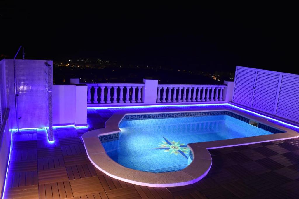 a swimming pool with purple lights on a building at BEACH HOUSE. CASA CON PISCINA PRIVADA in Calafell