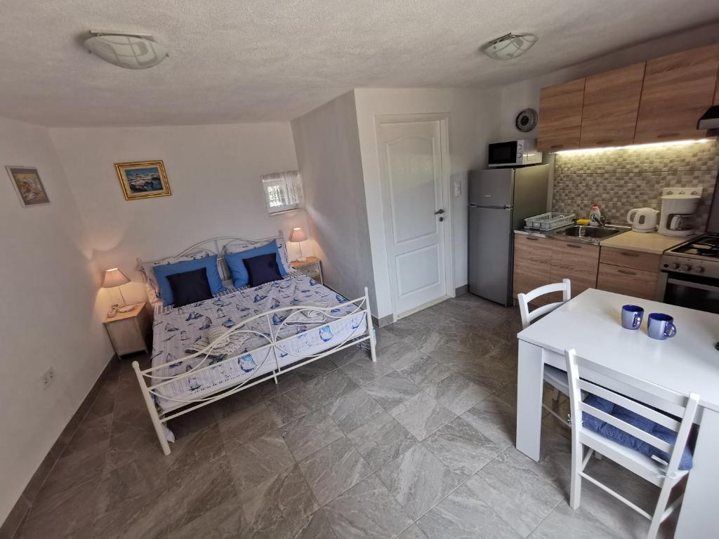 a small bedroom with a bed and a kitchen at Studio Apartment Mileta in Pitve