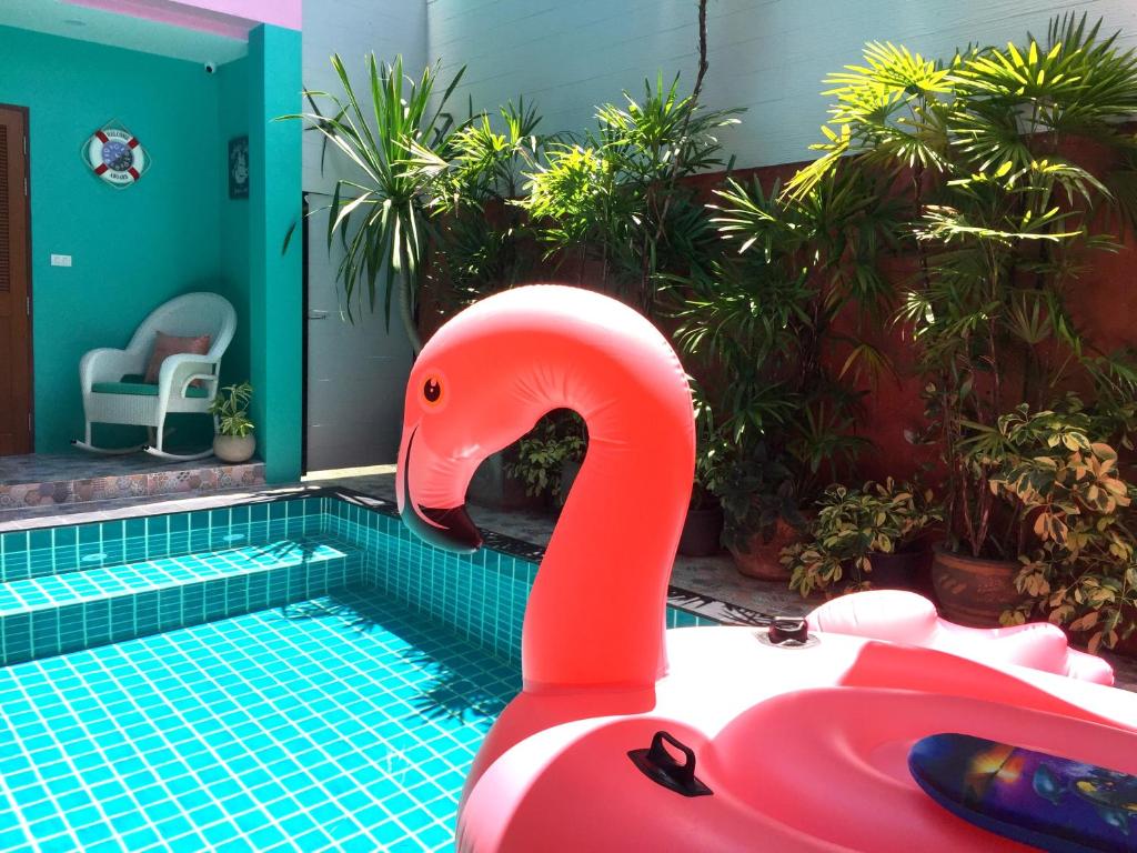 a pool with a pink flamingo in a swimming pool at Chor Chang House in Chiang Mai