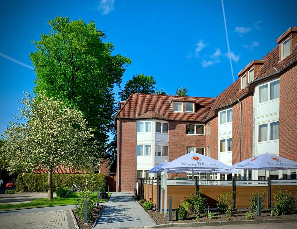 a building with two umbrellas in front of it at Hotel Stadt Aurich in Aurich