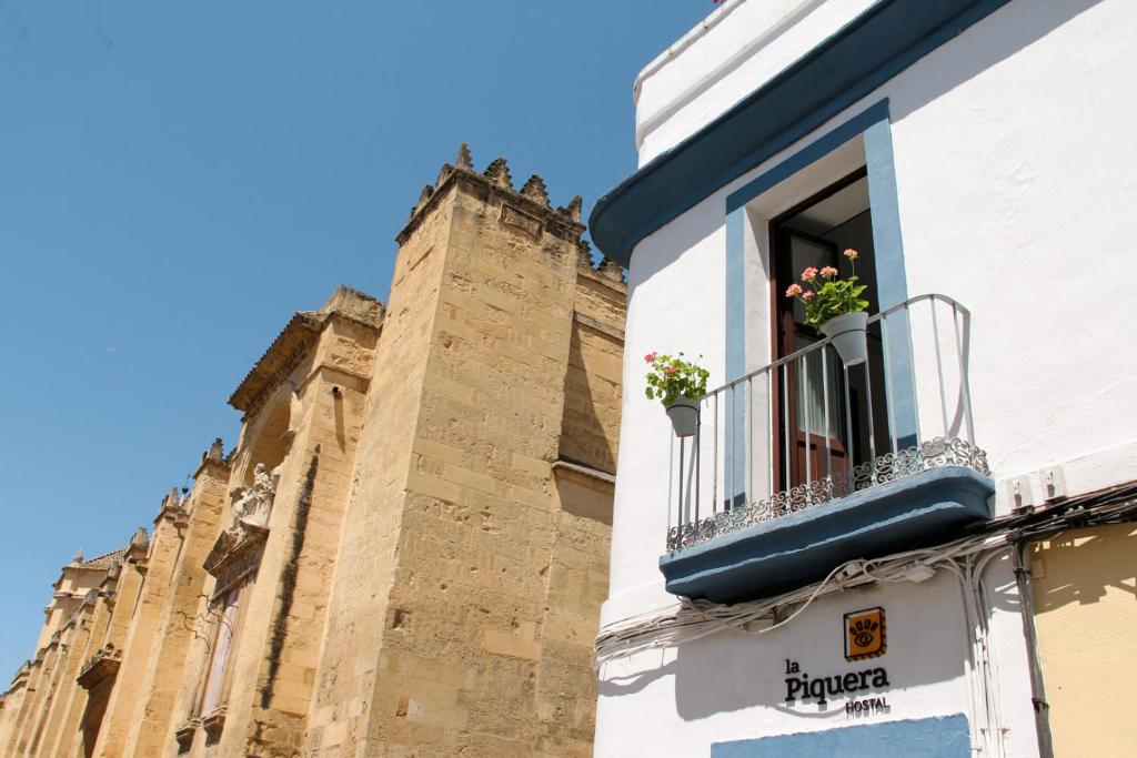 - un bâtiment avec une fenêtre fleurie dans l'établissement La Piquera Hostal, à Cordoue