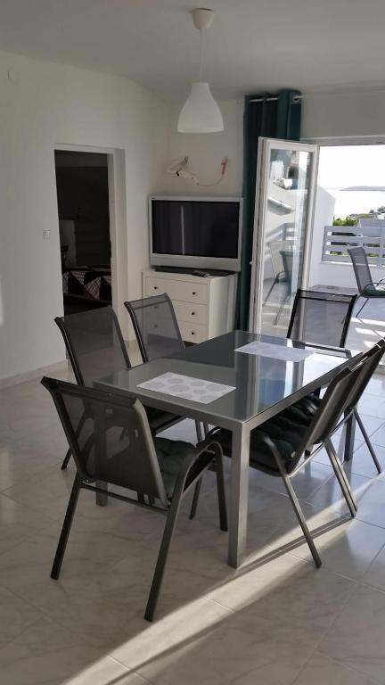 a dining room with a glass table and chairs at Big Blue - Xenija (Veliko Plavetnilo - Ksenija) in Metajna