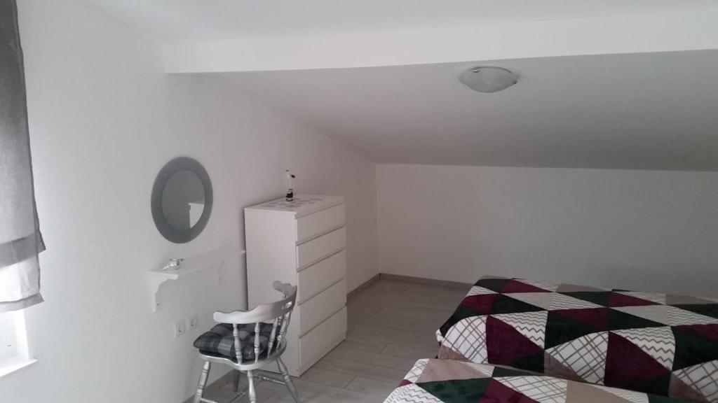 a bedroom with a bed and a mirror and a chair at Big Blue - Xenija (Veliko Plavetnilo - Ksenija) in Metajna