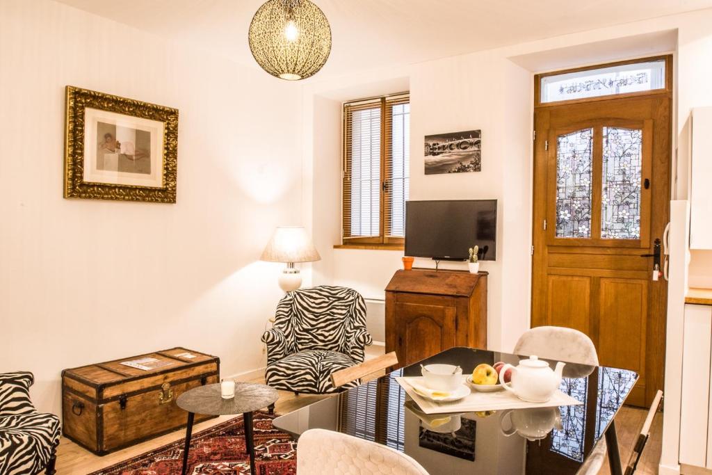 ein Wohnzimmer mit einem Tisch und einem Stuhl in der Unterkunft Le Petit Carmes - Joli studio de caractère in Toulouse