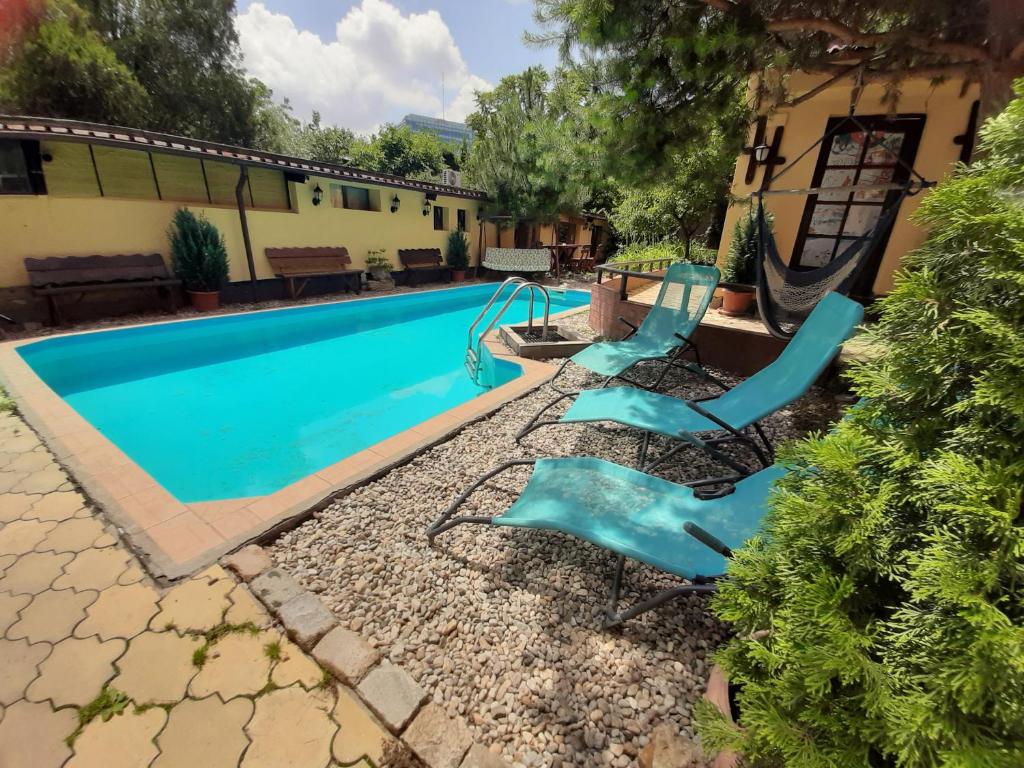 een zwembad met twee blauwe glijbanen in een tuin bij B&B Casa Mica Guesthouse in Boekarest