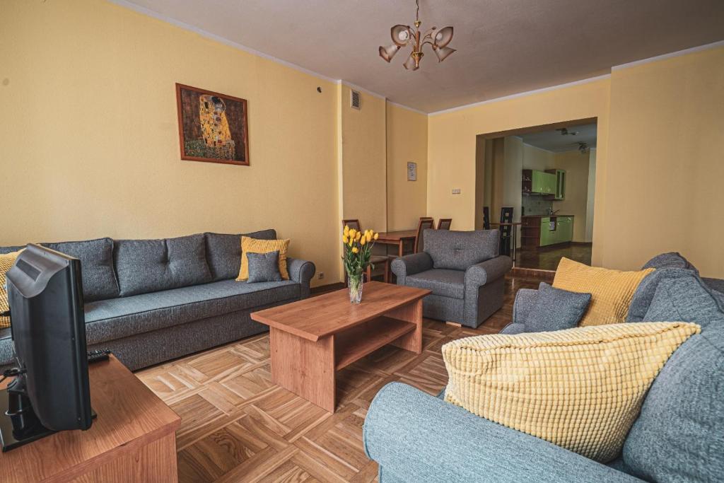 sala de estar con sofás azules y TV en Old City Apartments, en Riga