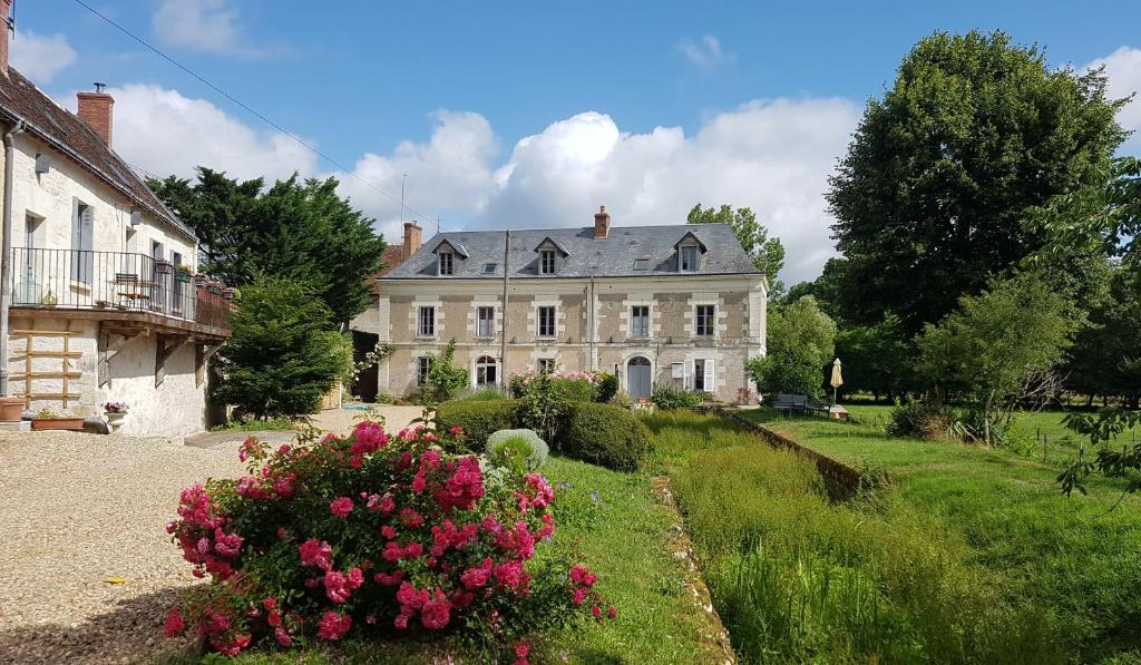 a large house with a garden in front of it at Le Moulin du Bourg in Épeigné-les-Bois