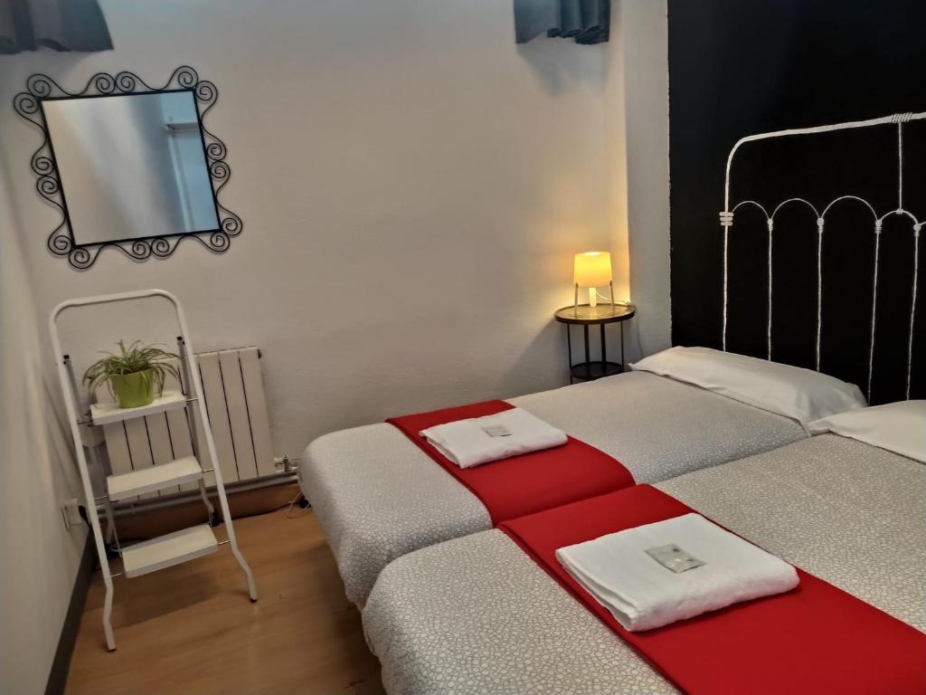 a bedroom with two beds and a mirror on the wall at Bilbao Akelarre Hostel in Bilbao