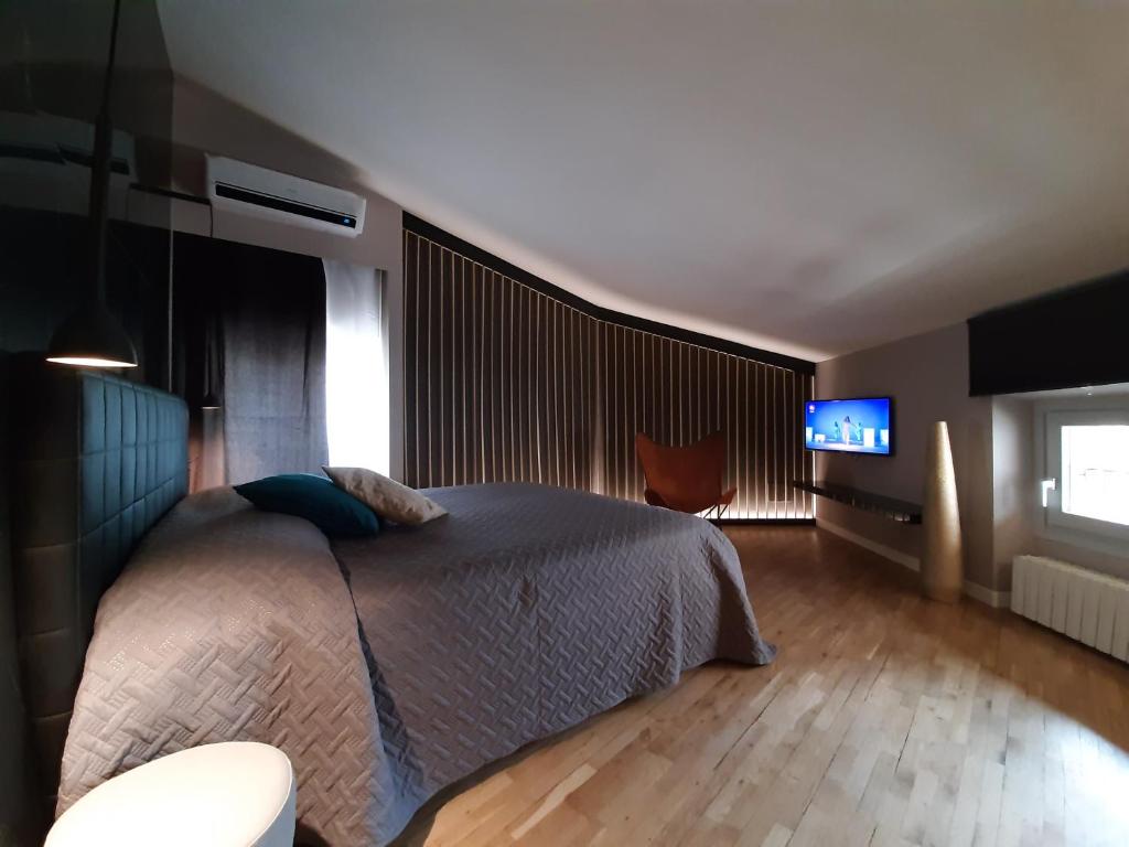 - une chambre avec un lit et une télévision à écran plat dans l'établissement MoAA - Modern Art Apartment, à Desenzano del Garda