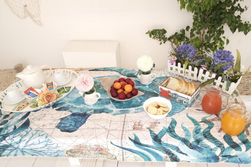 a table with a tray of food and fruit on it at Hotel San Giovanni in Polignano a Mare