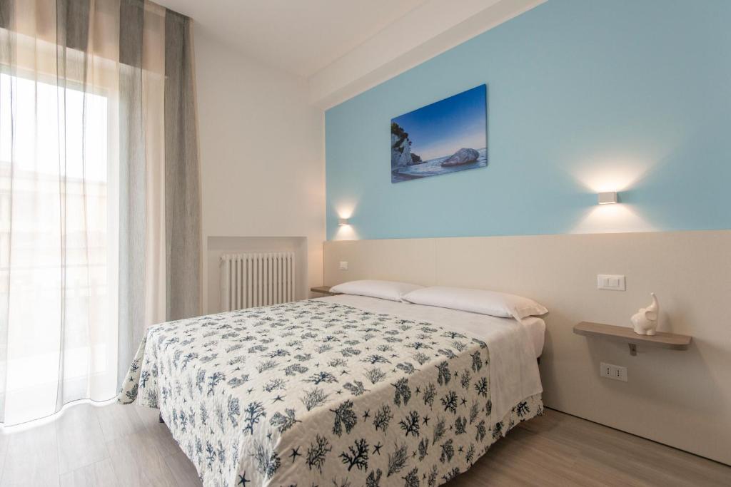ein Schlafzimmer mit einem Bett und einer blauen Wand in der Unterkunft Nel Conero Affittacamere in Numana
