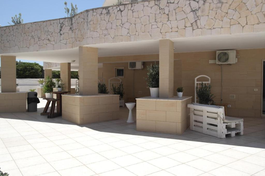 a large patio with a building with a stone wall at Hotel San Giovanni in Polignano a Mare