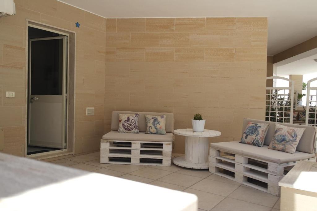 a patio with two chairs and a table at Hotel San Giovanni in Polignano a Mare