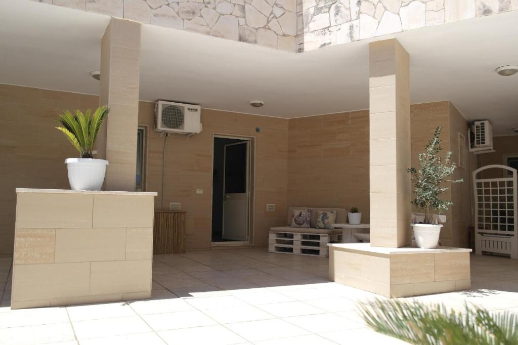a patio with two potted plants and a building at Hotel San Giovanni in Polignano a Mare