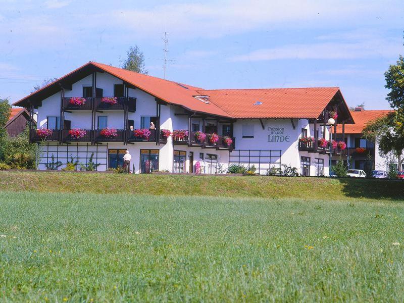 a large white building with a red roof at Pension an der Linde in Bad Birnbach