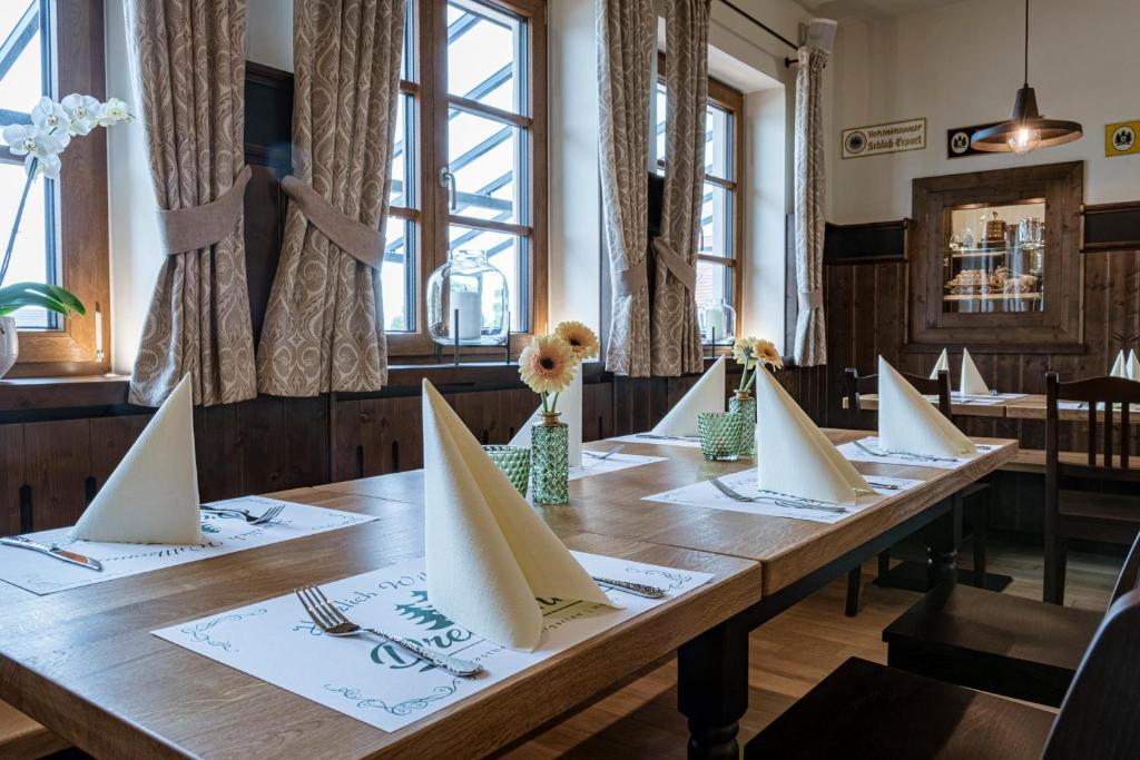 Gasthof Hotel Drei Tannen Altdorf في التدورف: طاولة خشبية عليها قوارب ورقية بيضاء