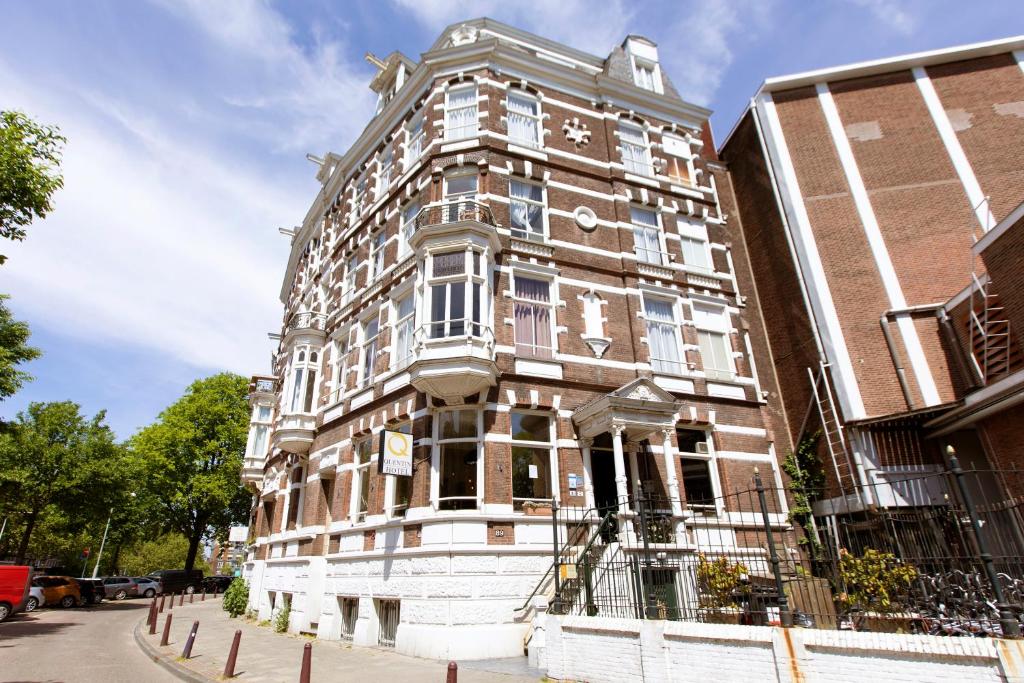 a large brick building on a city street at Quentin Amsterdam Hotel in Amsterdam