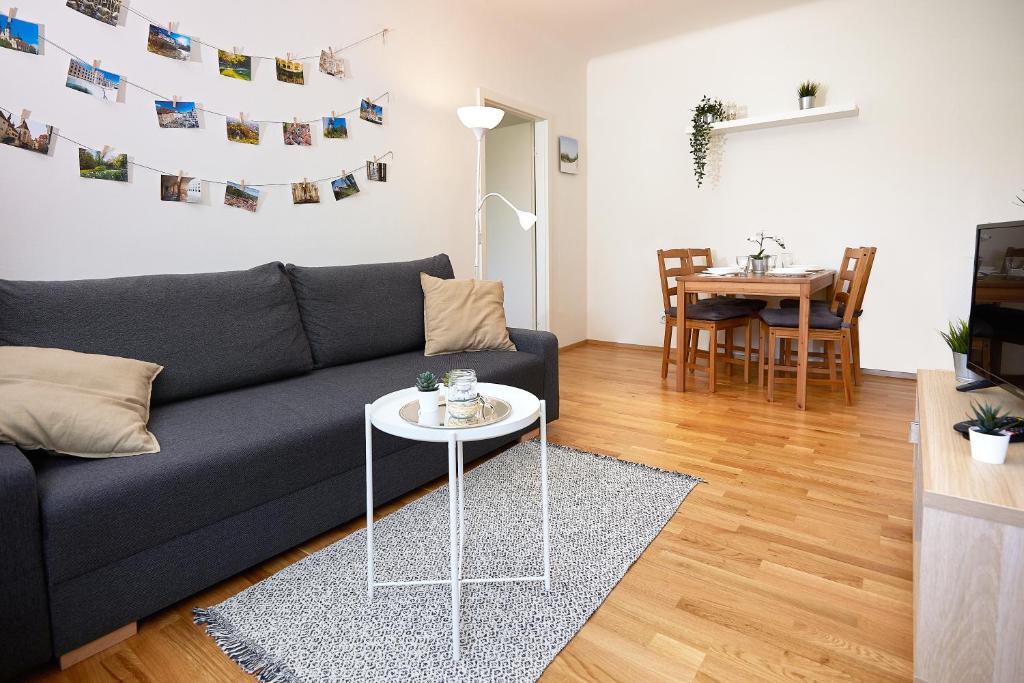 ein Wohnzimmer mit einem Sofa und einem Tisch in der Unterkunft Gemütliche Wohnung in zentraler Lage in Graz