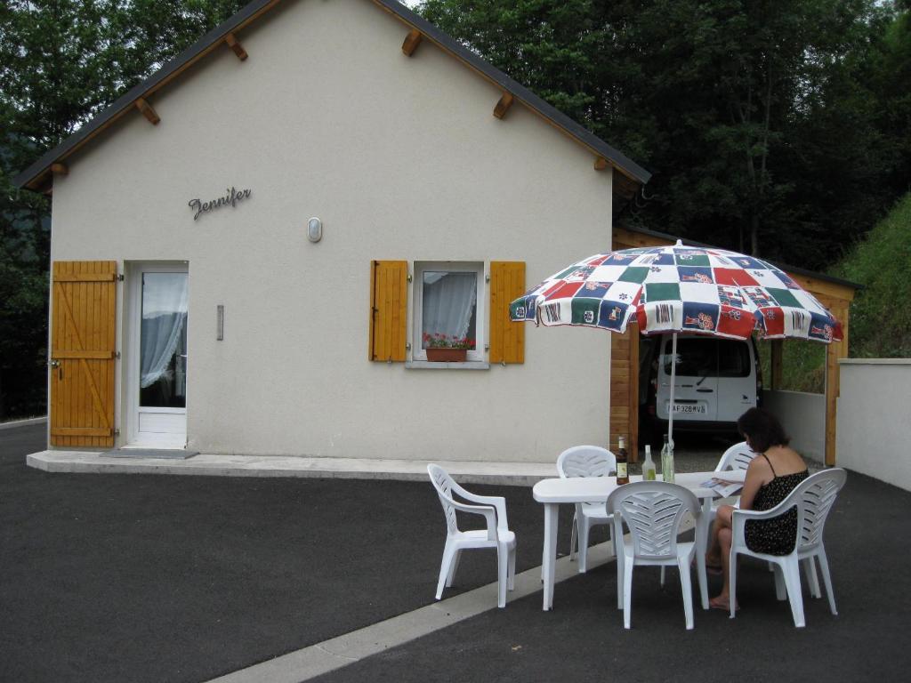 a woman sitting at a table with an umbrella at chalet jennifer in Laveissière
