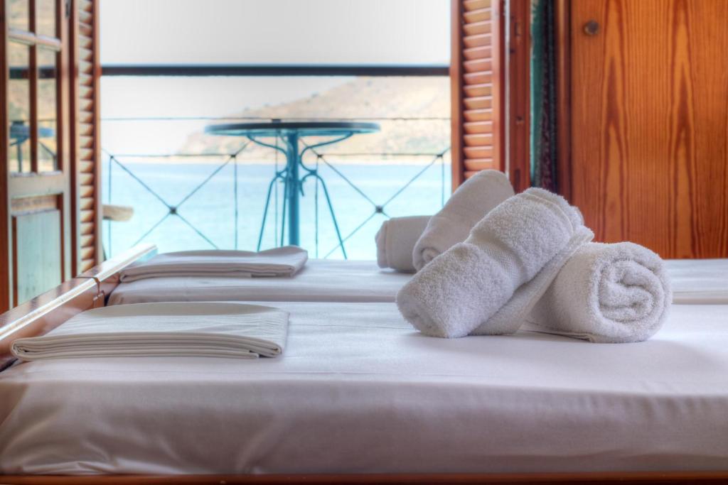 uma fila de toalhas sentadas em cima de uma cama em Guesthouse Palataki em Neon Oitilon