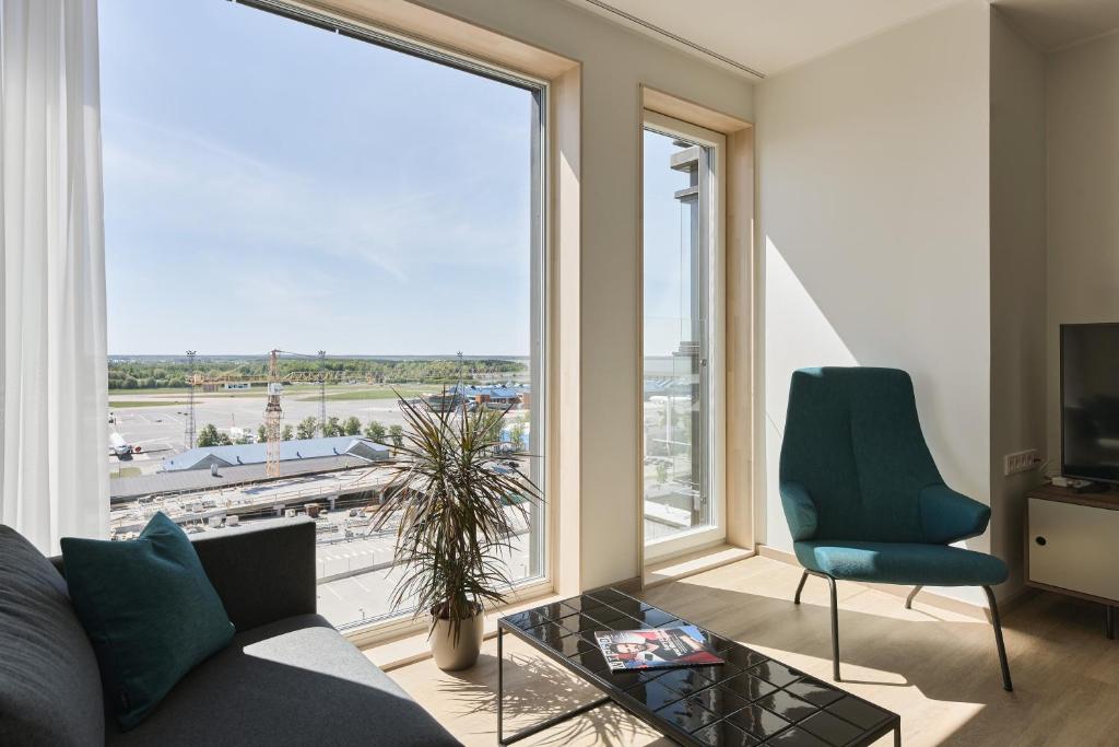 a living room with a couch and a large window at Ülemiste City Residences in Tallinn