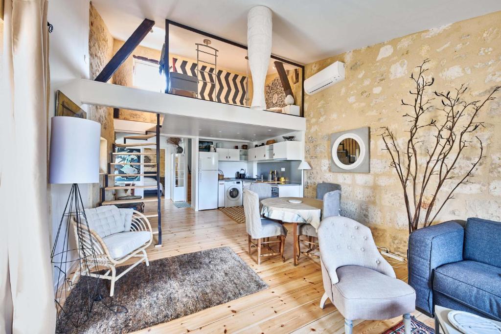 a living room with a blue couch and chairs at Elégant appartement tout confort avec climatisation dans le centre historique de ST Emilion in Saint-Émilion